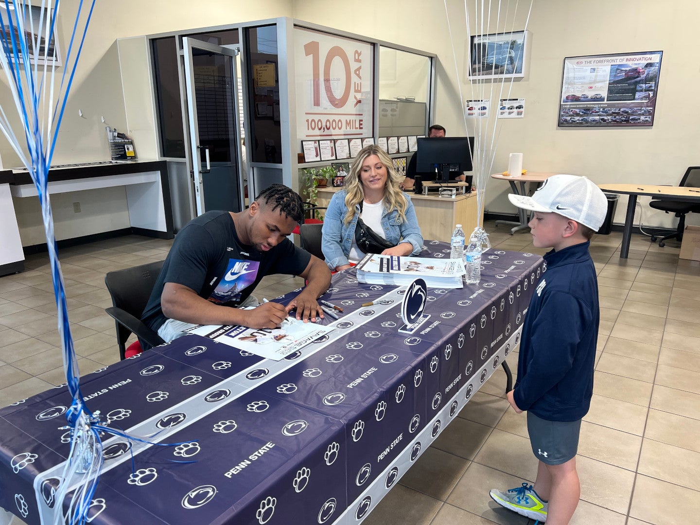 Nick Singleton giving an autograph to a child